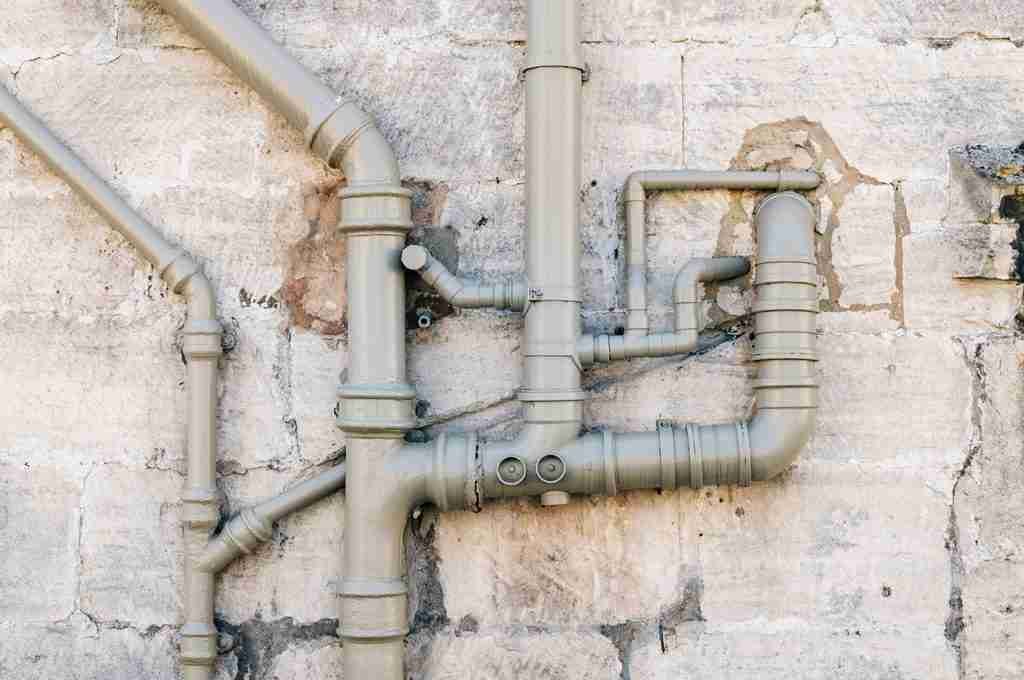 Sewer pipes on the stone facade