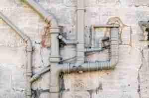 Sewer pipes on the stone facade