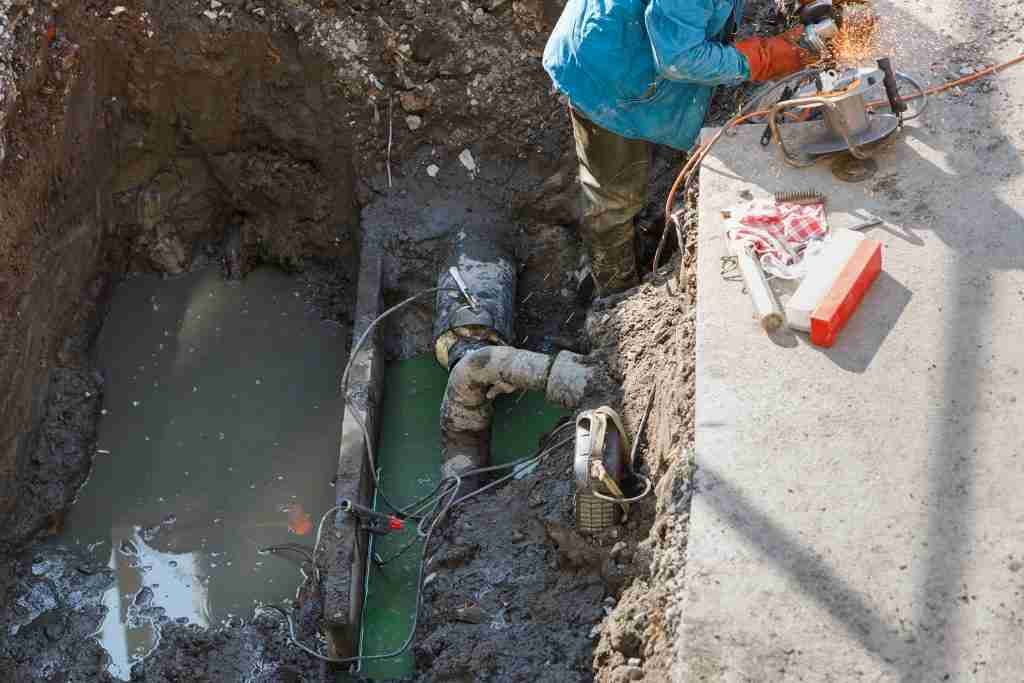 Utility worker fixing broken water main